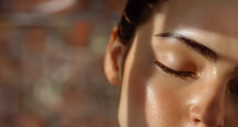 Close-up of a woman's face with warm lighting, highlighting smooth, radiant skin.